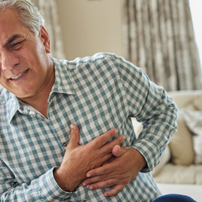 Mature Man Clutching Chest And Suffering Heart Attack At Home