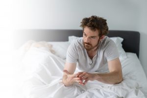 Man in bed looking upset