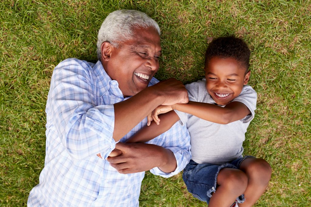 Grad Father Grandfather and grandson play lying on grass, aerial view – Deborah ...