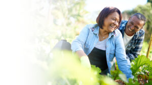 older couple smiling and working in the garden together